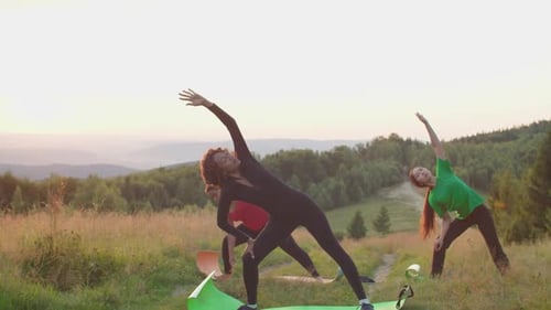 Women Stretching on Yoga Mats During Golden Hour