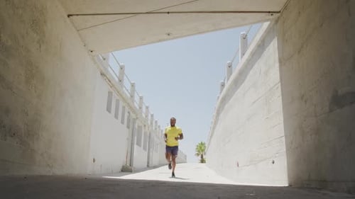Man Runs Through Concrete Tunnel Toward Sunlight