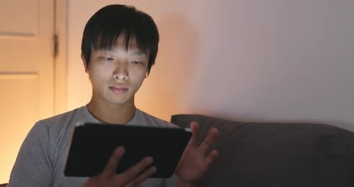 Man Use of Tablet Computer at Night