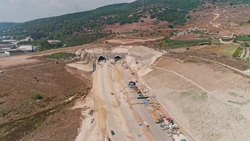 Aerial footage of large highway construction project with tunnels and bridges