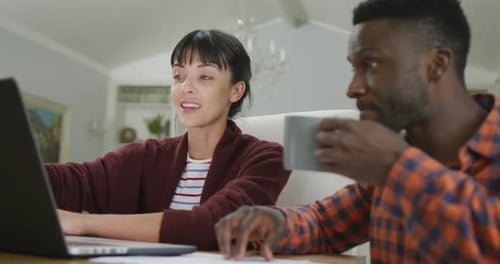 Young Couple Using Laptop at Table at Home