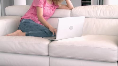 Woman Using Laptop on Couch in Modern Apartment