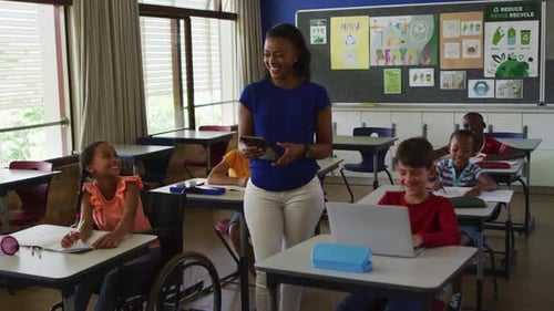 Teacher Smiles with Elementary School Children in Classroom