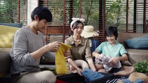 Family Packing Suitcase for Travel in Living Room