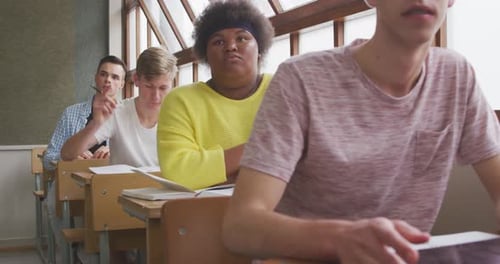 Students in Classroom Raising Hand to Answer Question
