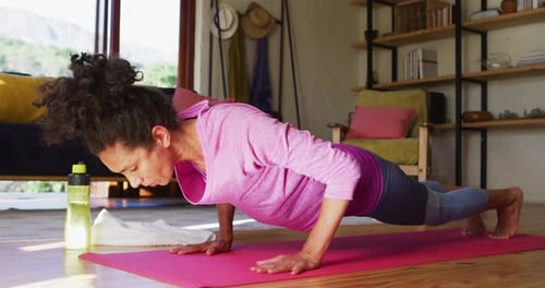 Woman Exercising Indoors on Pink Yoga Mat
