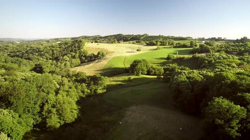 Aerial view of tractor harvesting straw bales in field, Correze, France.