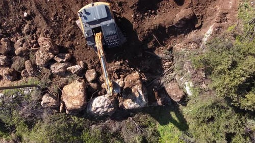 Crawler Bucket Making Walls Out of Rocks