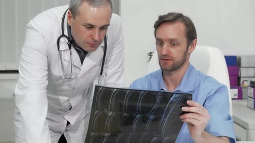Doctors Collaborating on X-Ray in Bright Office