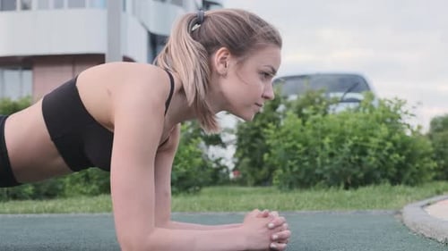 Belle femme sportive faisant de l'exercice sur sangle dans la rue