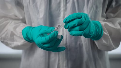 Pandemic Covid-19. A Close-up of the Doctor's Hand in Protective Gloves. The Infectious Agent Holds