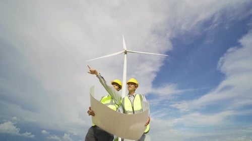 Engineers Reviewing Wind Turbine Plans on Site