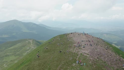 Aerial View of the Mountain Top with Many Young Hikers Against the Backdrop of a Mountain Landscape