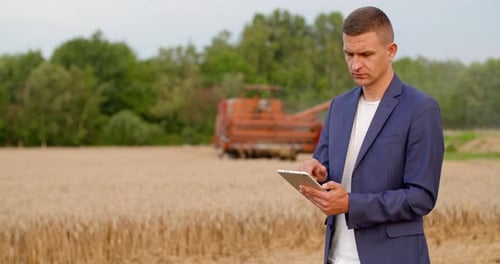Man Uses Tablet in Wheat Field
