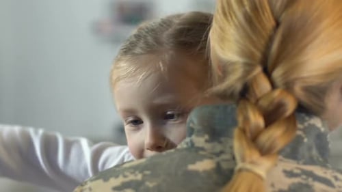 Loving Child Hugging Mother in Military Uniform