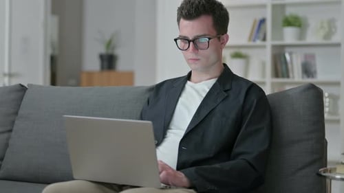 Young Adult Working on Laptop at Home