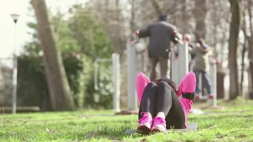 Young woman doing abs exercises at park