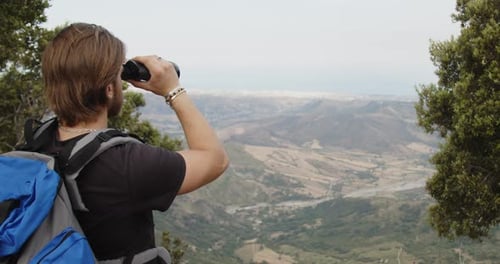 Hiker with Binoculars Enjoys a Mountain View