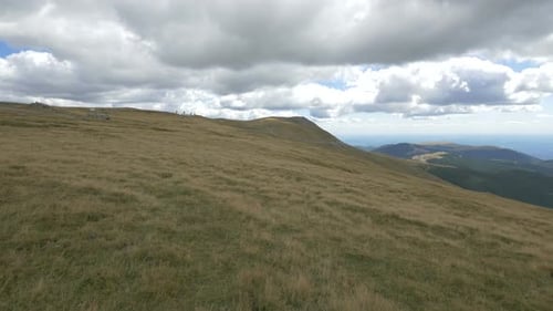 Grassy Mountains Landscape with Cloudy Sky