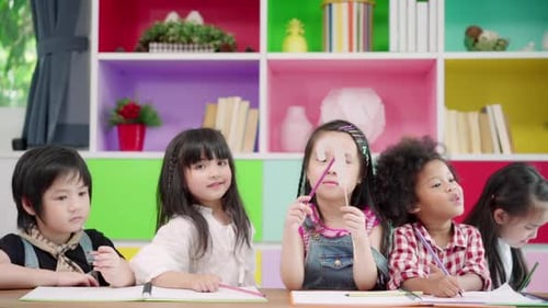 Multi-ethnic young boys and girls happy funny study and play painting on paper at elementary school