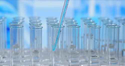 Blue Liquid Being Poured into Test Tubes