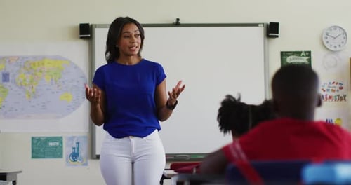 Portrait of mixed race female teacher standing in classroom conducting a lesson