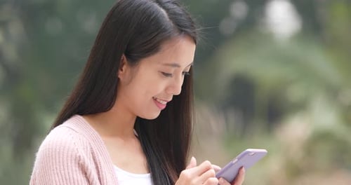 Woman Using Smart Phone in Urban Park