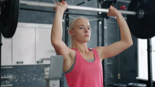 Young Sportswoman Lifting Heavy Barbell Working Out Alone in Gym Wearing Trendy Sportswear