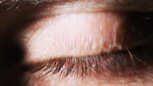 Männliches Auge Extreme Nahaufnahme. Erstaunlich blinkendes Männerbraun mit grünem Auge Sicht.