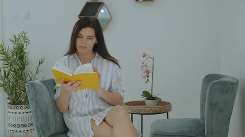 Young Woman Reading a Book at Home