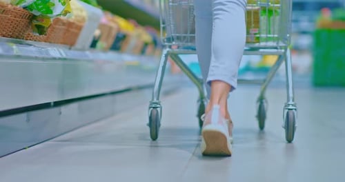 Women's Feet in Sneakers Walking Around the Supermarket
