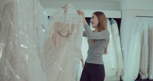 Garotas felizes escolhem um vestido de noiva