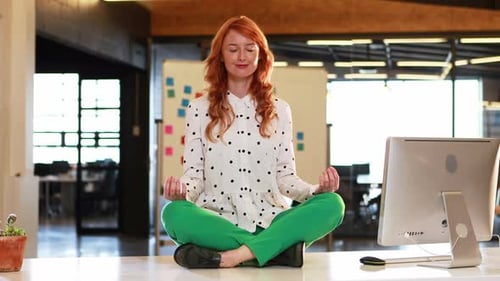 Woman Meditating in Office for Wellbeing and Balance