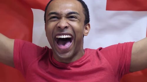 Enthusiastic Young Man Celebrates with Flag