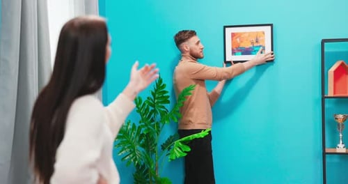 Couple Decorating Home with Abstract Art