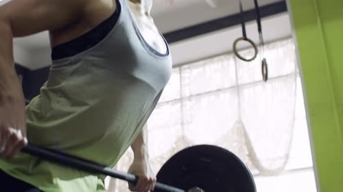 Sportswoman Training with Barbell