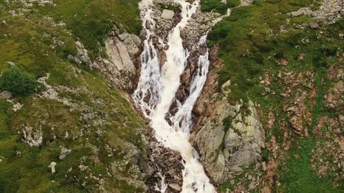 Mountain Fast River Flows Through a Steep Rocky Gorge with Small Waterfalls Aerial View
