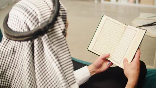 Man Reading the Quran Indoors