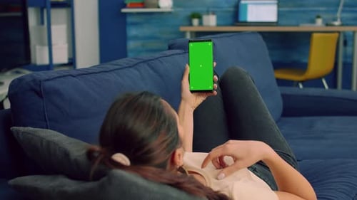 Casual Woman Holding Smartphone with Mock Up Green Screen