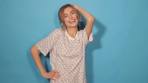 Attractive girl posing in studio near blue wall