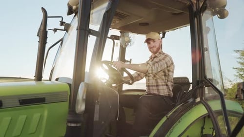 Male Driving a Green Tractor on Farm