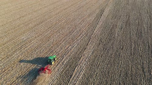 Tractor Tilling Golden Field Aerial View