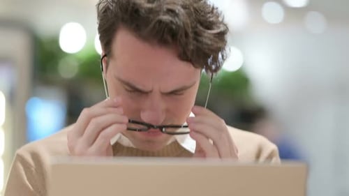 Close Up of Man with Laptop Having Headache