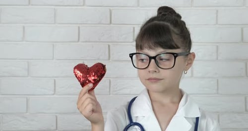 Child Doctor Holding Heart in White Room
