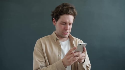 Man with Mobile Phone Reacts with Excitement
