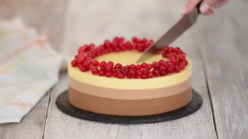 Delicious Mousse Cake Being Sliced with a Knife