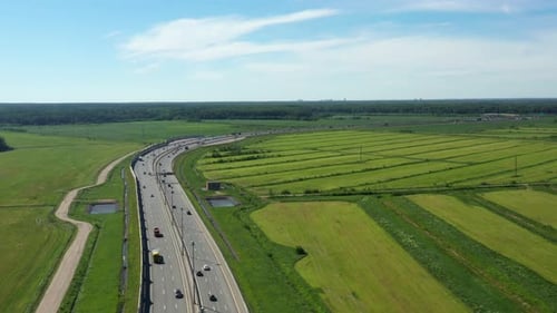 Asphalt Speedway with Cars Through Green Field. Aerial View From Drone
