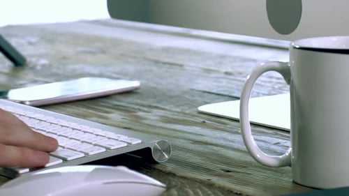 Ein kaukasischer Mann tippt auf einer kabellosen Tastatur 03