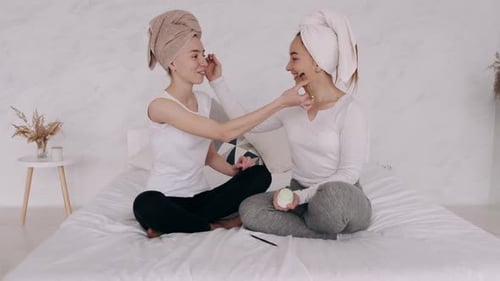 Women Applying Makeup to Each Other Indoors