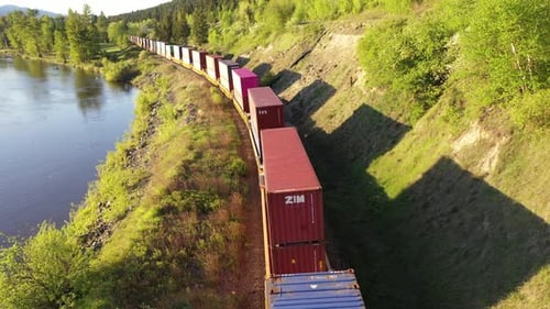 Aerial view of freight train passing by a river